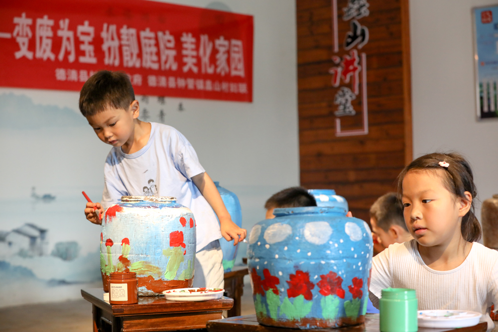 小朋友對廢棄瓦罐進行藝術創造。白羽攝