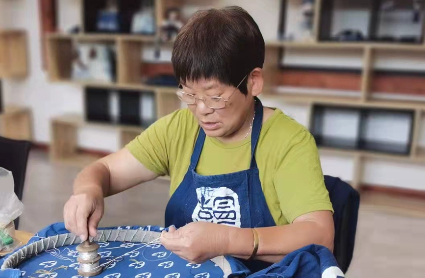 村民在藍印花布上進行金銀繡。段凌云攝