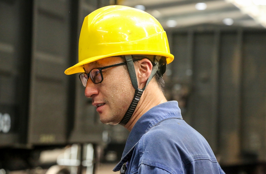 倪高明從車底下鉆出來，全身被汗濕透。汪晟攝