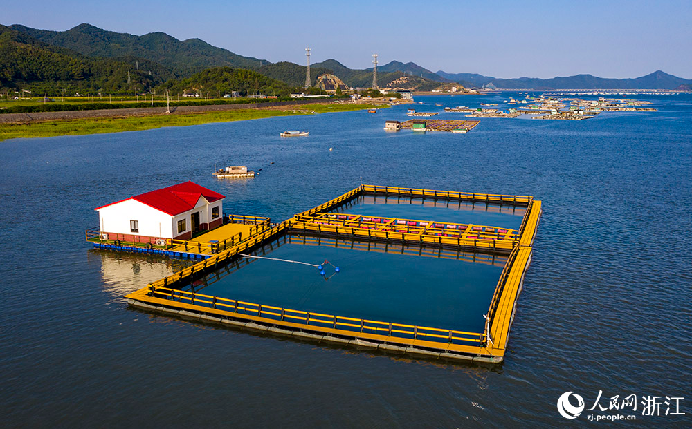 一方方橙黃色的養殖設施有序排列在蔚藍的海面上，成為斑斕海岸線一道亮麗的風景。人民網 章勇濤攝