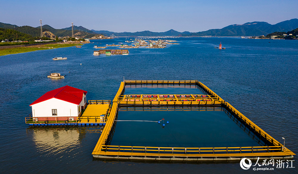 一方方橙黃色的養殖設施有序排列在蔚藍的海面上，成為斑斕海岸線一道亮麗的風景。人民網 章勇濤攝