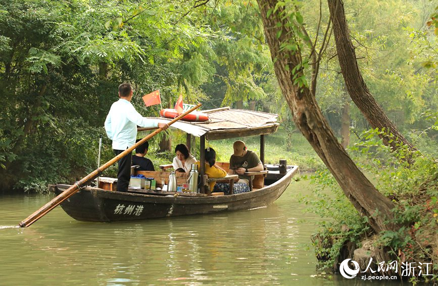游客乘坐搖櫓船欣賞西溪秋日風光。人民網 方彭依夢攝