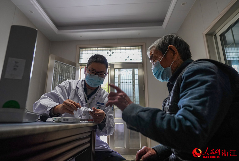 余利明叮囑老人要按時按量服藥。人民網 章勇濤攝