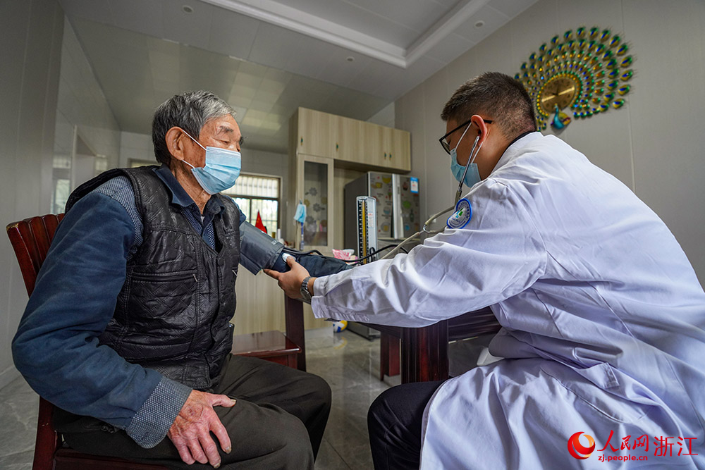 浙江省慈溪市觀海衛鎮“家庭病床”醫生余利明上門為85歲的茅忠全進行隨診。人民網 章勇濤攝