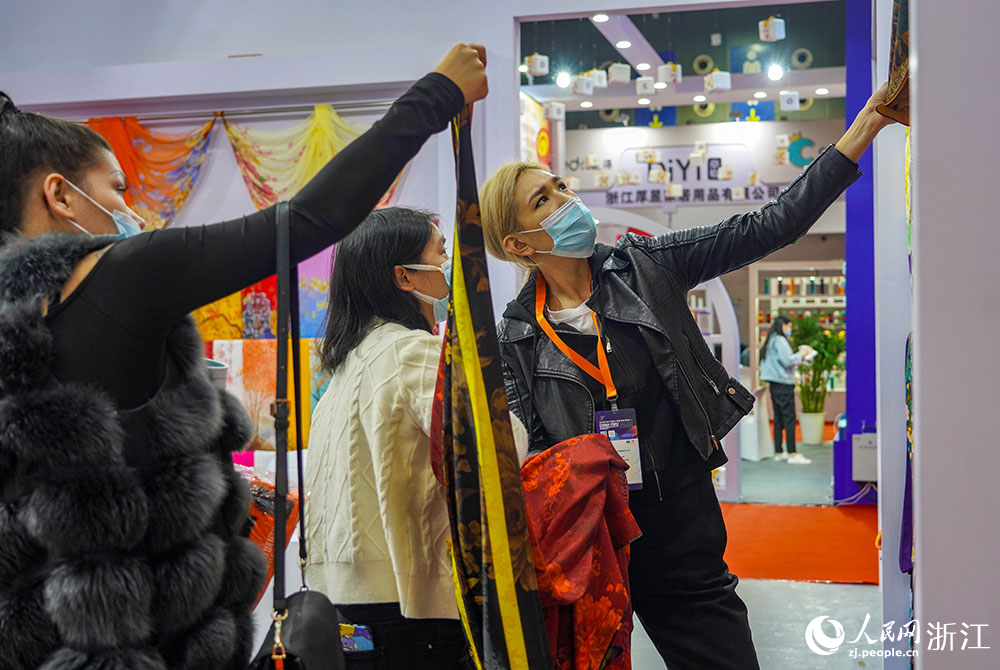 11月24日，來自俄羅斯的客商Aku（右一）在義烏國際博覽中心采購圍巾。人民網 章勇濤攝