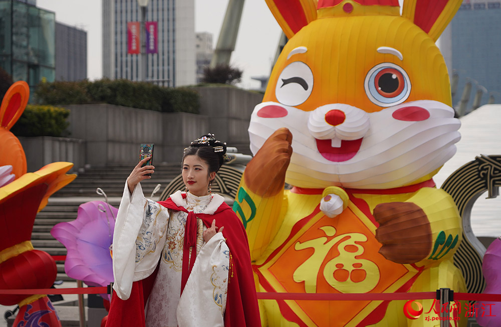 在杭州市拱墅區朝暉街道，身穿漢服的市民在兔年吉祥物前合影。人民網 章勇濤攝
