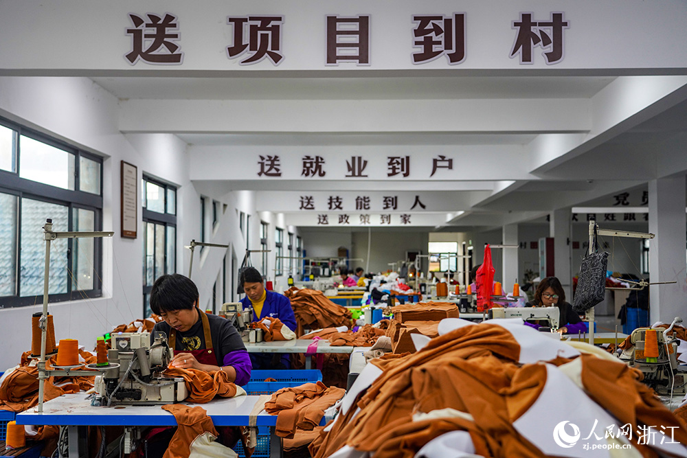 在浙江省臺州市仙居縣田市鎮水閣村“共富工坊”，工人們忙著趕制服裝。人民網 章勇濤攝