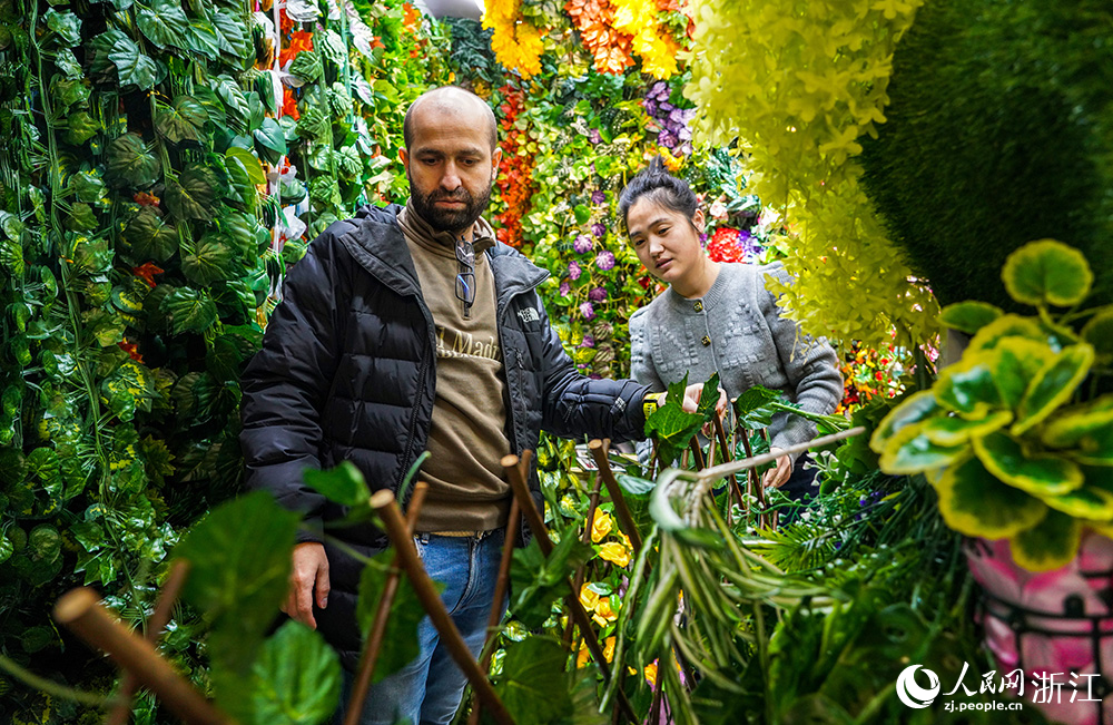 在浙江義烏國際商貿城，外商（左）正在選購小商品。人民網 章勇濤攝