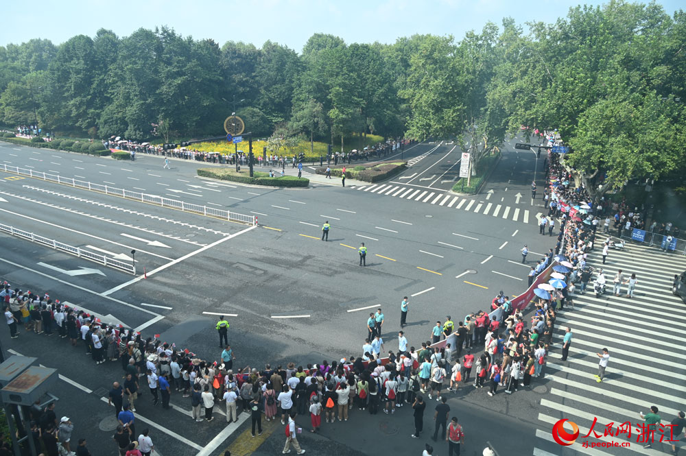 一大早，火炬傳遞路線沿線就來了很多為火炬手加油的市民和游客。人民網 葉賓得攝