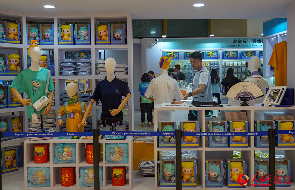 人們在杭州亞運會主媒體中心內的官方特許商品零售店選購。人民網 章勇濤攝