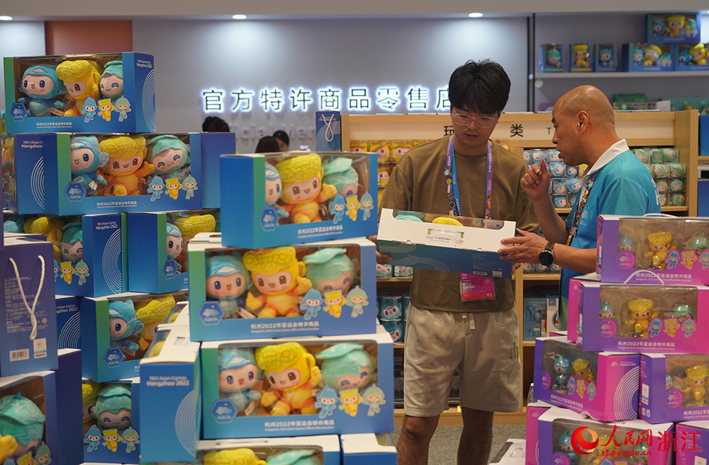 人們在杭州亞運會主媒體中心內的官方特許商品零售店選購。人民網 章勇濤攝