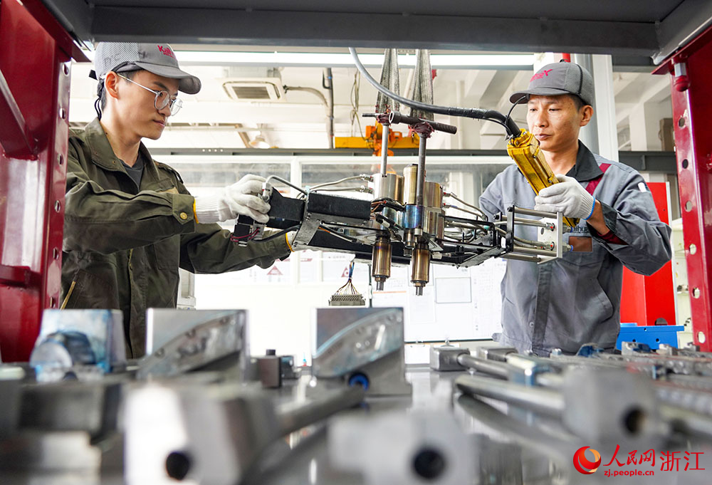 在臺州科技職業學院凱華模具產業學院，學生（左）在吊裝模具。人民網 章勇濤攝