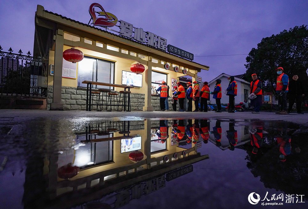 在浙江省慈溪市觀海衛鎮，環衛工人排起長隊，領取愛心早餐。人民網 章勇濤攝