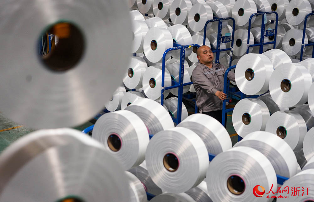 在浙江省紹興市柯橋區的一家化纖企業，工人在生產線上作業。人民網 章勇濤攝