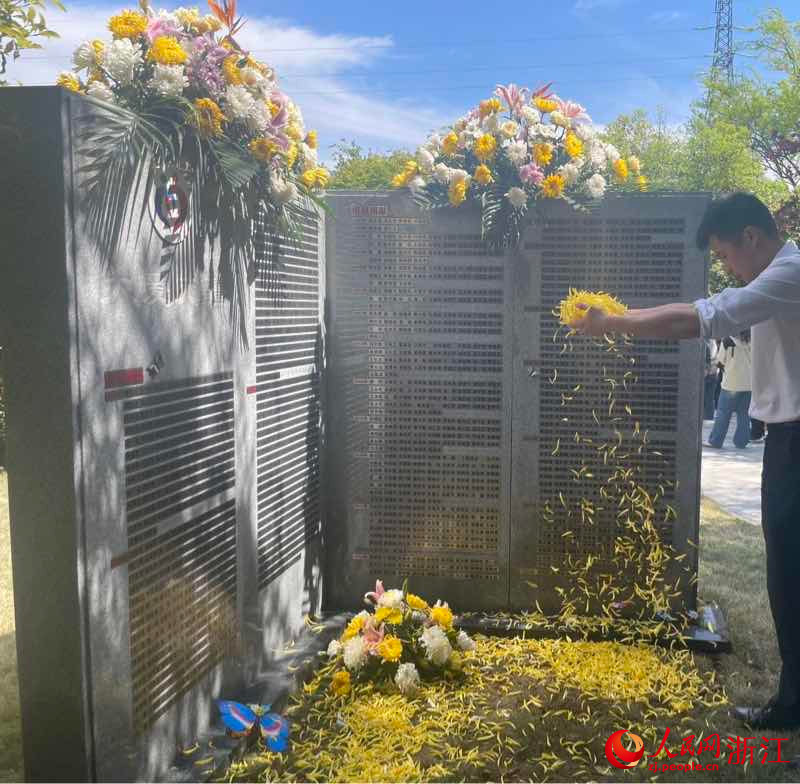 工作人員為捐獻者紀念碑敬獻菊花。人民網 秦銘澤攝
