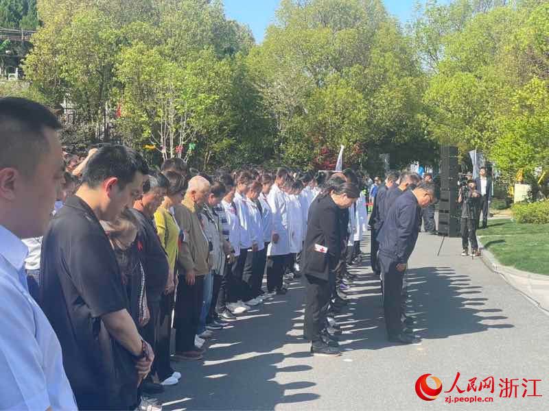 活動現場嘉賓、捐獻者家屬等人默哀。人民網 秦銘澤攝