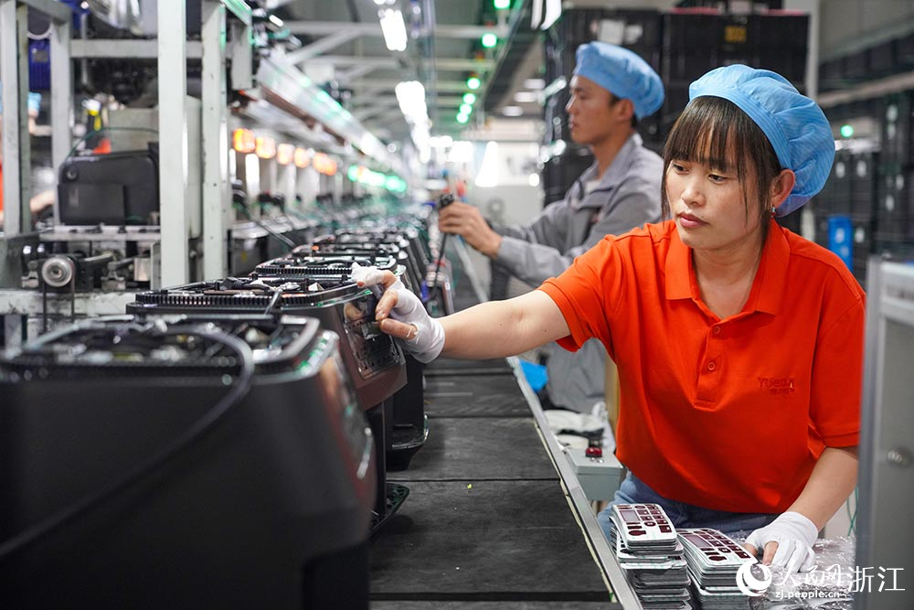 在浙江省慈溪市觀海衛鎮一家制造空氣炸鍋的企業，工人在生產線上忙碌著。人民網 章勇濤攝