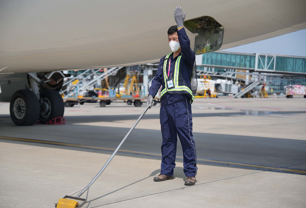飛機排污員正在指揮污水車到位。吳承予攝