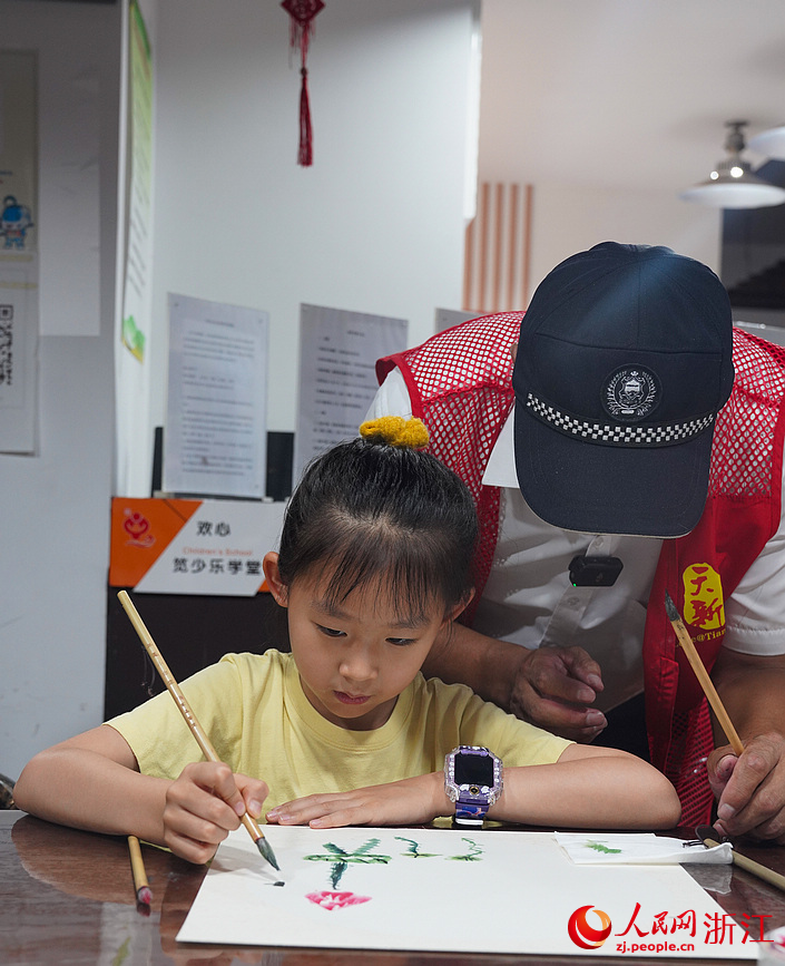 遇到難點，郭建合會手把手地教小朋友如何走筆。人民網記者 郭揚攝