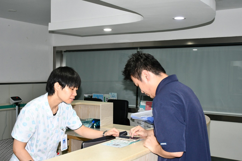 在醫院護士的指導下，新手爸爸學習辦理線上醫保。徐奕唯攝