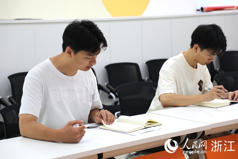 郝宇航（左）組織召開社區書記助理晨會。人民網 方彭依夢攝