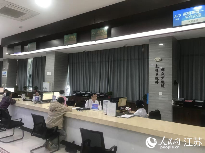 在江蘇宜興市徐舍鎮便民服務中心的“高頻事項一平臺”辦理專窗，墻上寫著“數據多跑路，群眾少跑腿”。人民網 俞楊攝