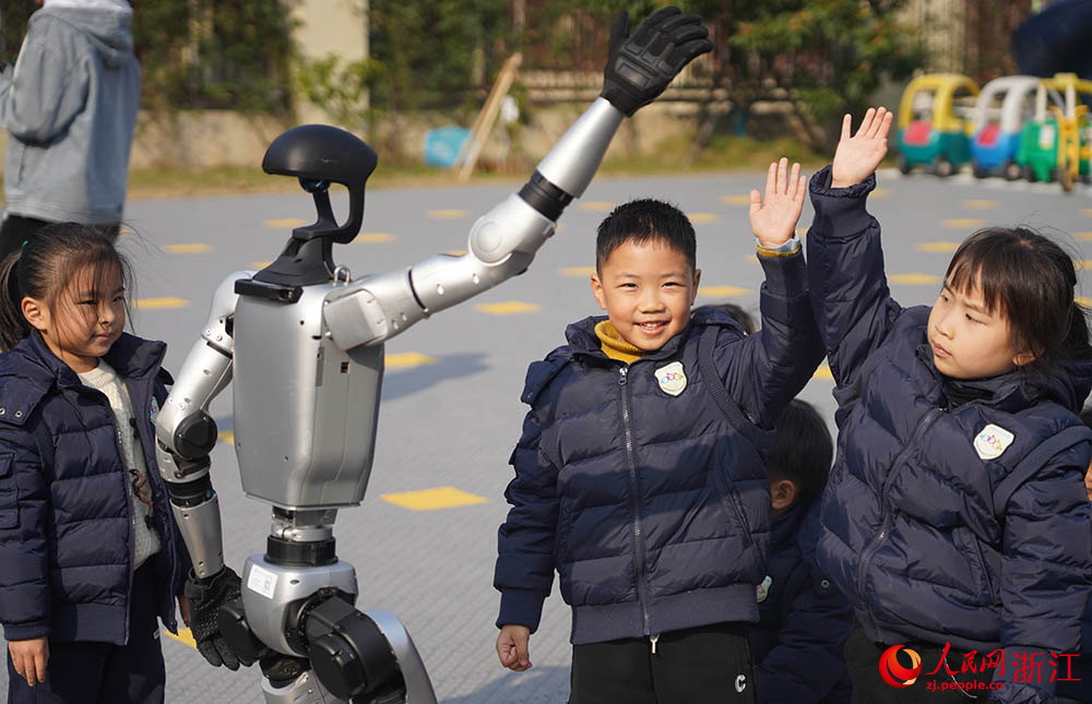 在寧波市江北區慈城懷之幼兒園，孩子們和人形機器人同步動作。人民網 章勇濤攝