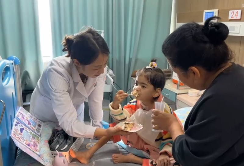 小依依在吃生日蛋糕。浙大兒院供圖