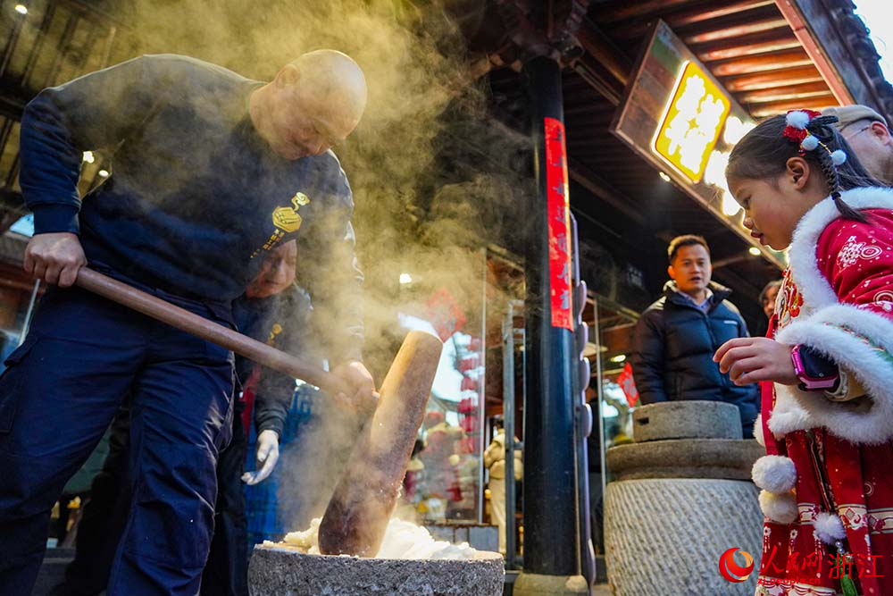 寧波市江北區慈城古縣城，市民游客觀看搗年糕。人民網 章勇濤攝