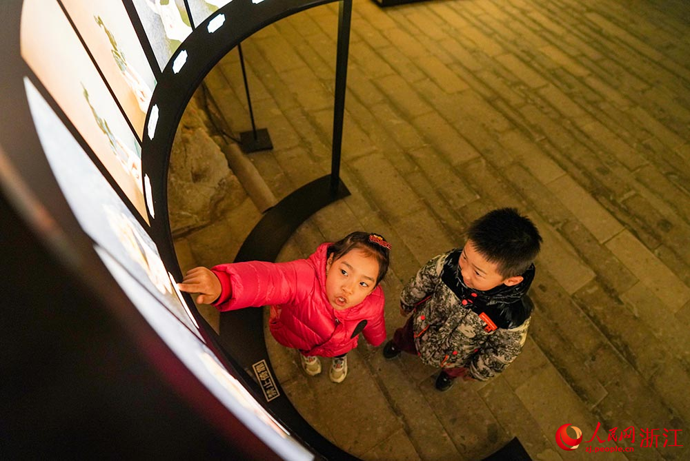 在浙江省臺州市黃巖石窟，小朋友在觀看展覽。人民網 章勇濤攝