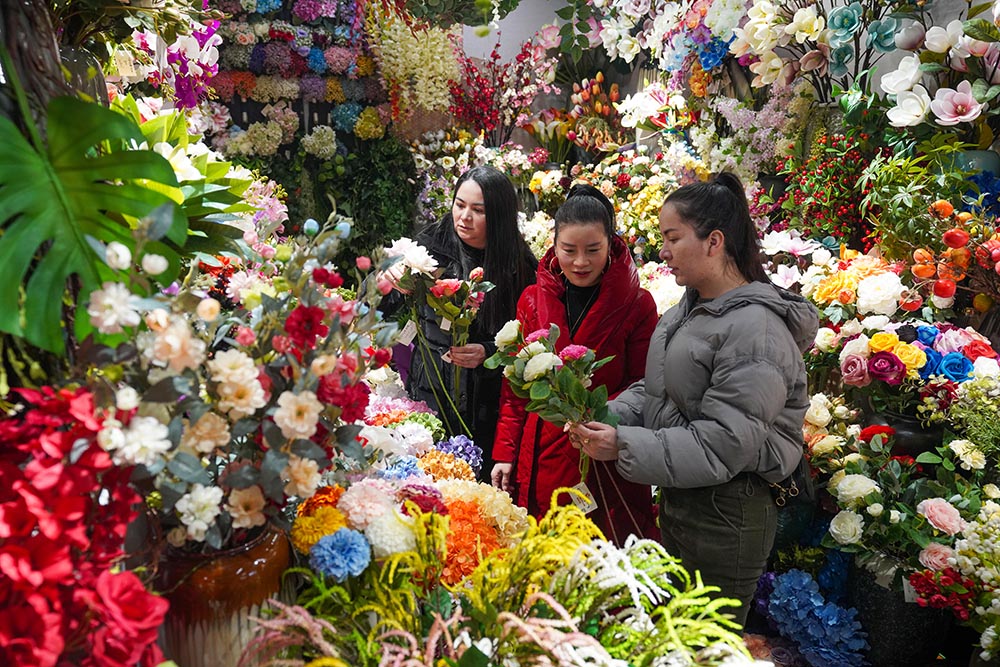 在浙江義烏國際商貿城，外商和市場經營戶在洽談仿真鮮花生意。人民網 章勇濤攝