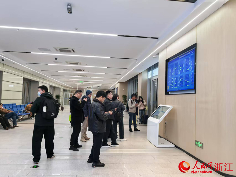 乘客根據電子顯示屏找尋車輛位置。人民網 章勇濤攝