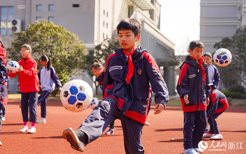 在浙江省臺州市黃巖區新前街道中心小學校園內，學生們在快樂踢球。人民網 章勇濤攝