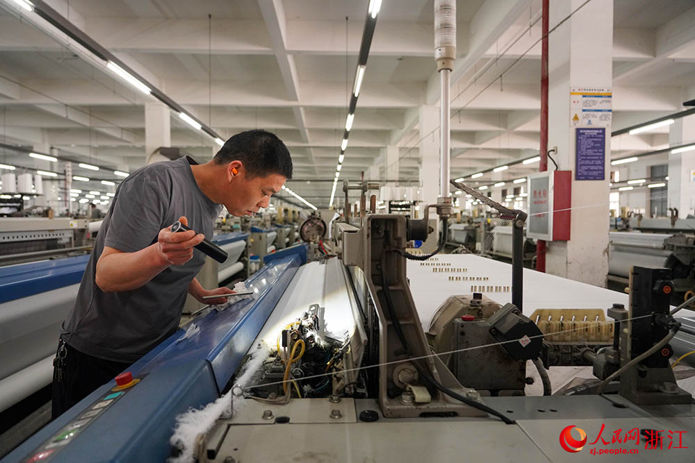 在浙江省紹興市柯橋區一家紡織企業，工人在生產線上趕制訂單。人民網 章勇濤攝
