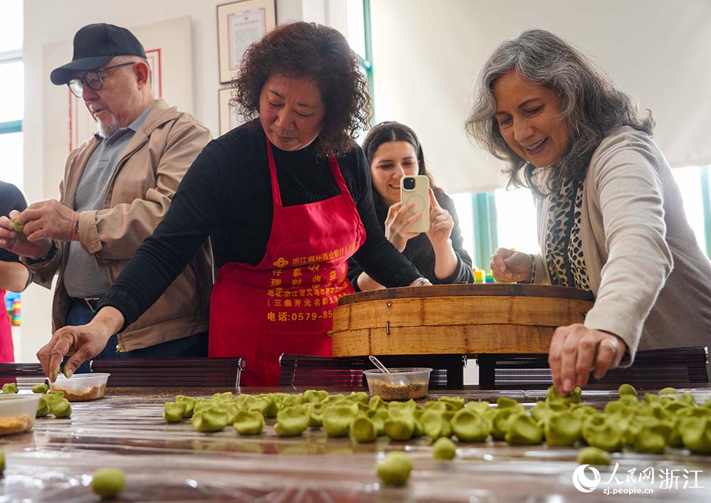 浙江省義烏市江東街道雞鳴山社區中外居民共同制作清明果。人民網 章勇濤攝