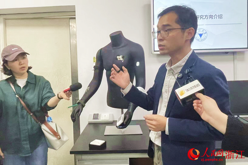 浙江大學生物醫學工程與儀器科學學院特聘研究員梁波介紹研究所研制的穿戴式血氧指環。人民網記者 王麗瑋攝