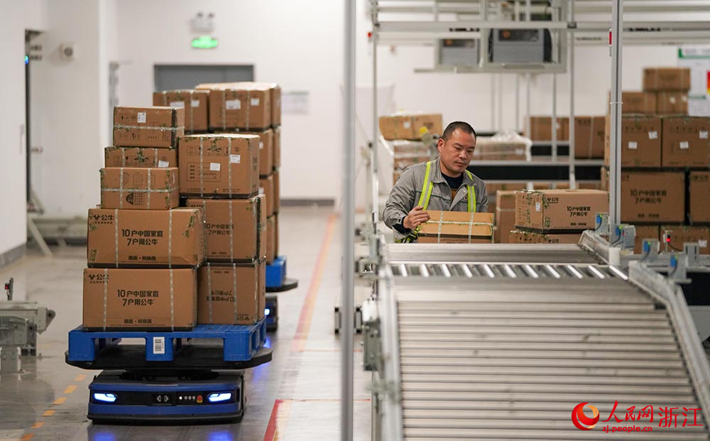 在浙江省慈溪市觀海衛鎮一家電企業，工人按照集貨線路正在搬運貨物。人民網 章勇濤攝