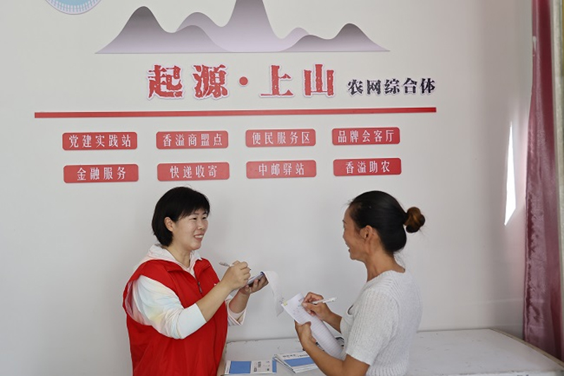 浦江煙草工作人員同店主共同建設農網綜合體。樓松文/攝