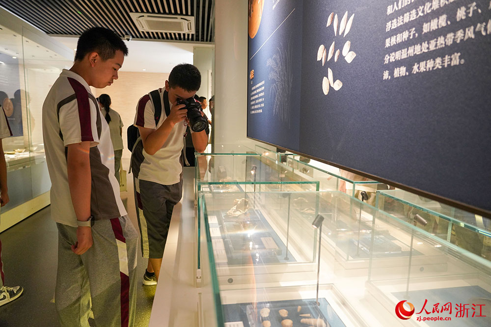 溫州朔門古港遺址考古成果展現場，學生們駐足凝視一件件出土文物。人民網 章勇濤攝