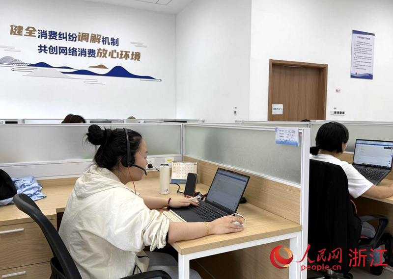 余杭區市場監管局網監分局的人工調解員正在處理網絡消費投訴案件。人民網 方彭依夢攝