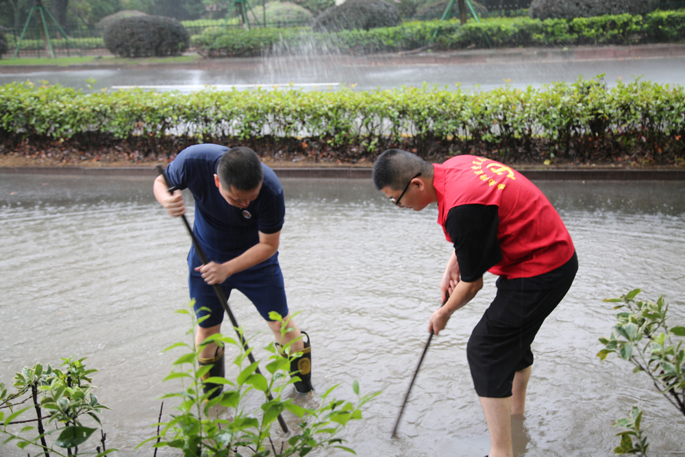 黨員、消防隊員疏通低洼易澇路段積水。章玲婧攝