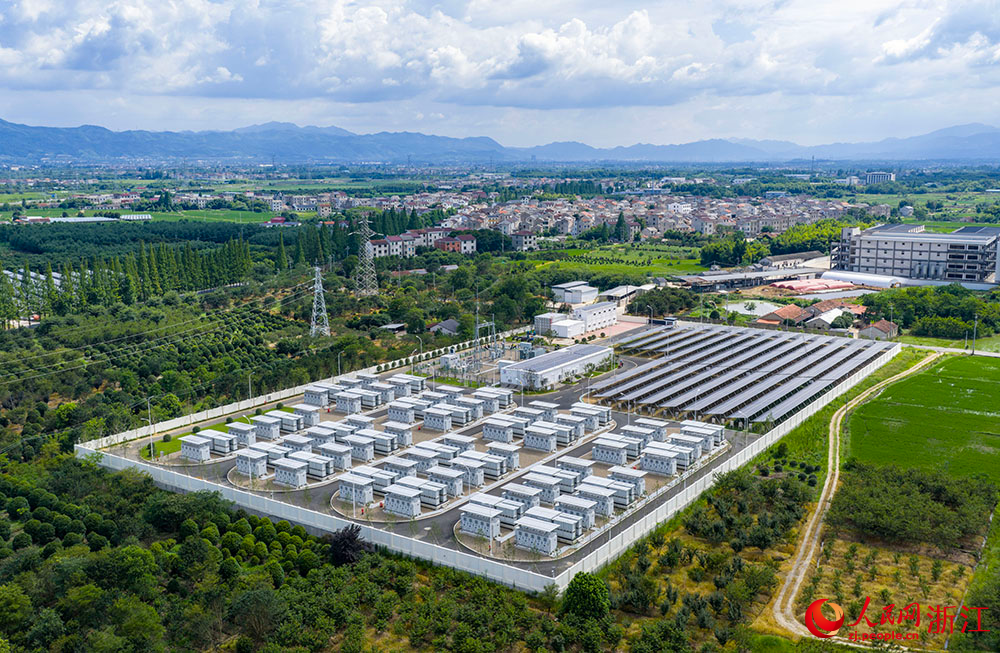 陽光下的光伏板陣列熠熠生輝，與一排排白色儲能電池整齊排列，共同構成蓄勢待發的“電力糧倉”。人民網 章勇濤攝