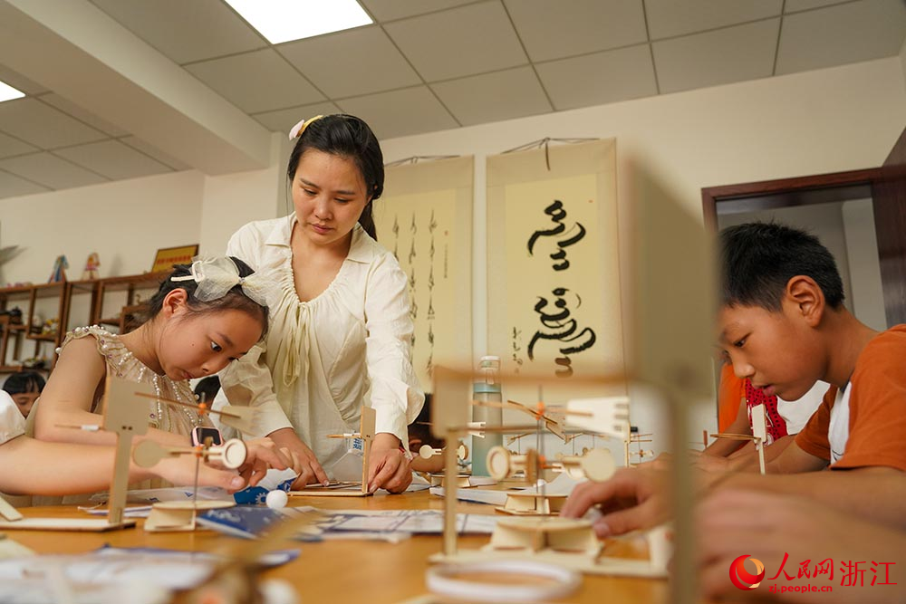 在浙江省嘉興市秀洲區洪合鎮“石榴紅”暑期課堂上，小朋友們在進行科學實驗。人民網 章勇濤攝