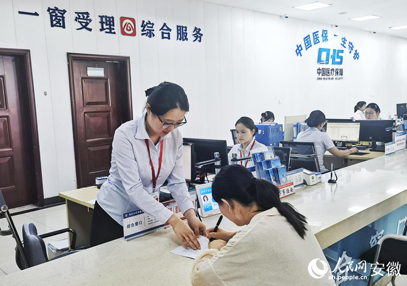 鳳陽縣政務服務大廳“高效辦成一件事”窗口前，工作人員正在指導市民填表。人民網記者 周坤攝