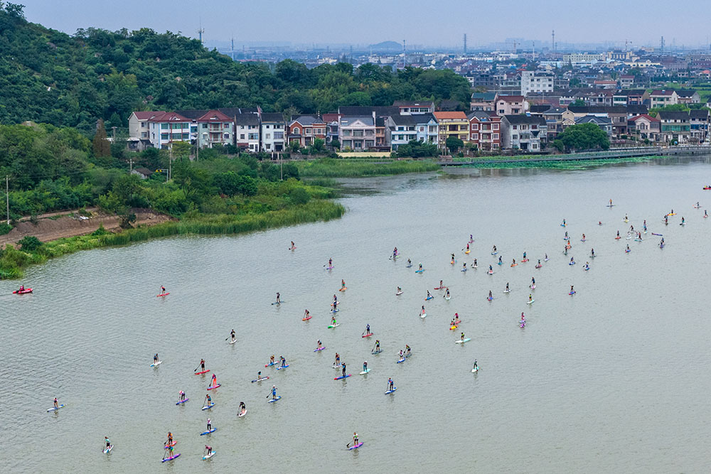 9月21日，在浙江省慈溪市觀海衛鎮，一塊塊色彩斑斕的槳板與鄉村的白墻黛瓦、遠山碧水交織成一幅動感十足的現代風景畫。人民網 章勇濤攝