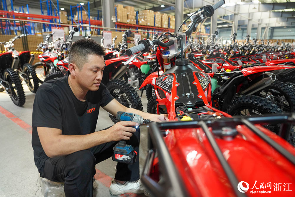 9月28日，位于浙江省麗水市縉云縣華洋賽車的生產車間里，工人們正忙著調節非道路越野摩托車。人民網 章勇濤攝