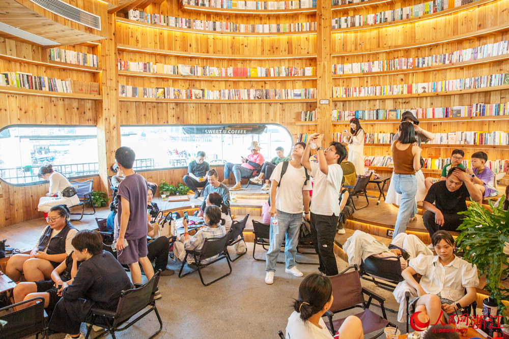 10月7日，浙江省溫州市蒼南縣金鄉鎮石砰碼頭，由擁有數十年歷史的老油庫改造而成的咖啡館內，游客們喝咖啡、品書香、賞海景，盡享假日休閑時光。人民網記者 葉賓得攝