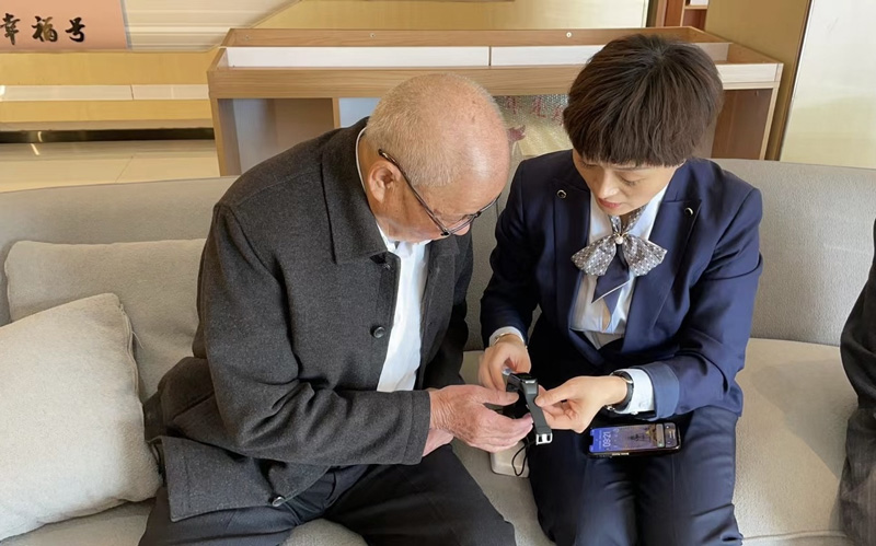 工作人員向老人介紹智能手環。浙江移動供圖