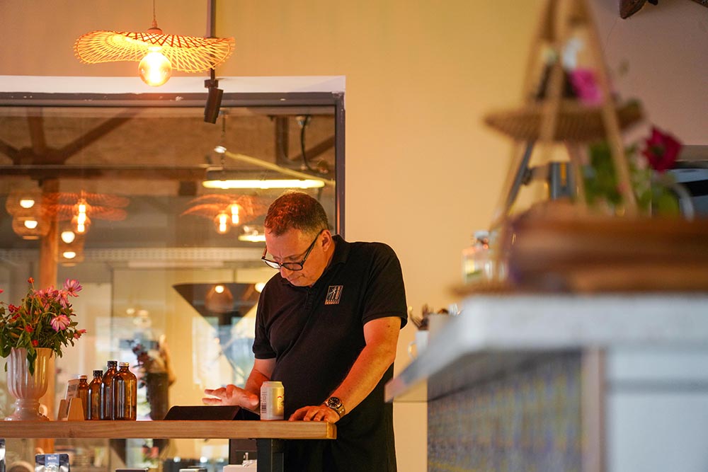 暮色漸濃，咖啡館內暖燈亮起，弗蘭克在進行每日清點。