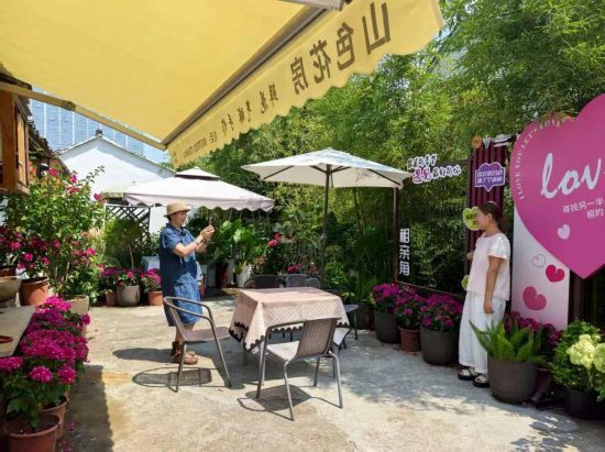 鄭曉貞為游客拍照留念?？鲁菂^委宣傳部供圖